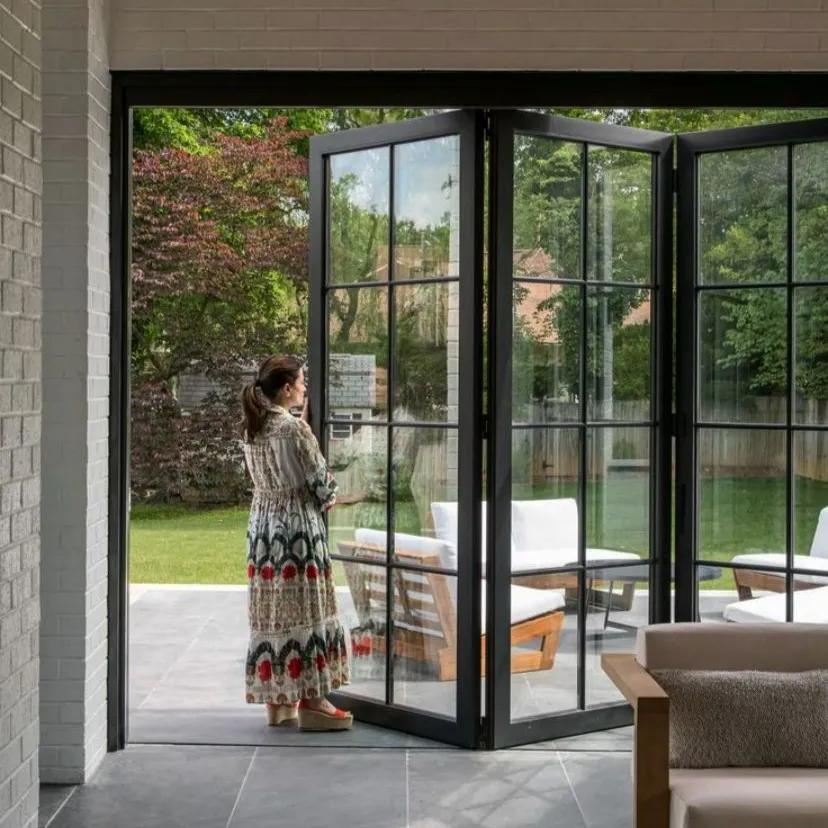 Black steel-look bifold doors opening a home to the garden